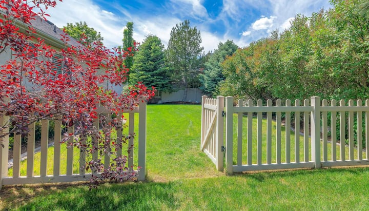 A functional fence gate providing access to a well-maintained backyard, surrounded by a wooden fence in Katy